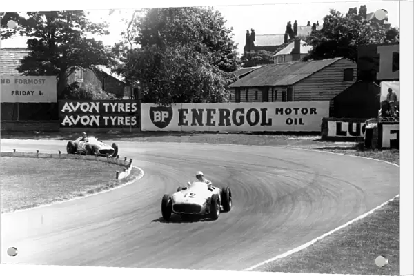 British racing driver Stirling Moss No 12, takes the lead from Fangio of Argentina