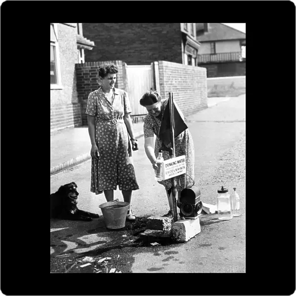 Mrs Gardaner and Mrs Weatherall draw drinking water from stand pipes which have been