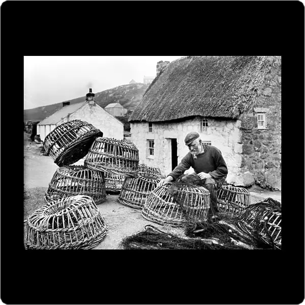 Bill Harvey inspecting fishing nets, Porthgwarra, Cornwall. June 1903