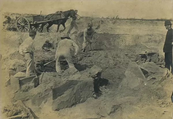 Workmen uncovering a group of cists at the excavation site of the Iron Age cemetery at Harlyn Bay, St Merryn, Cornwall. 1900