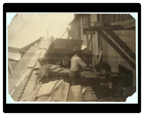 Charlie McBride aged 12 takes wood from a chute for 10 hours at Miller & Vidor Lumber Company