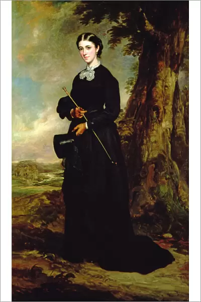 Young woman wearing a black riding habit and standing in a landscape