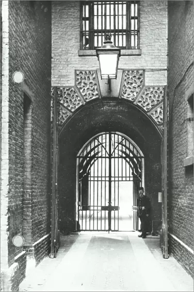 Millbank Prison: main passageway, Warden Barnard in doorway, 1885 (b  /  w photo)