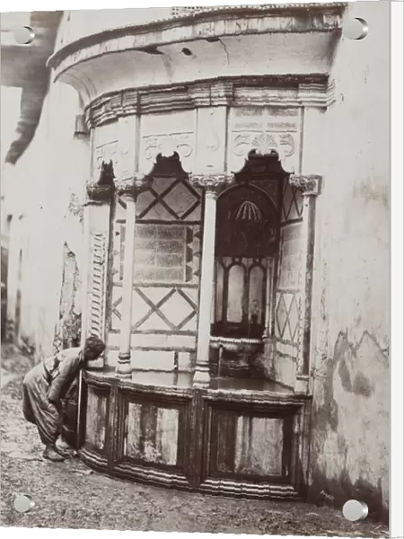 A man drinking from a corner fountain, on a street in Damascus, Syria