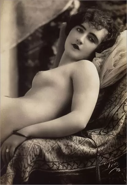 A young woman posing nude on a couch