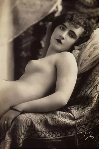 A young woman posing nude on a couch