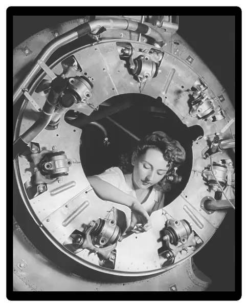 A woman assembles part of the cowling of a B-25 bomber motor. circa 1942