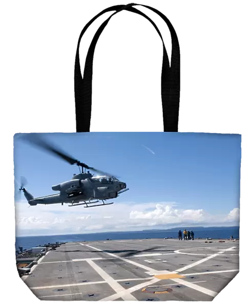 An AH-1W Super Cobra helicopter lands aboard USS Denver