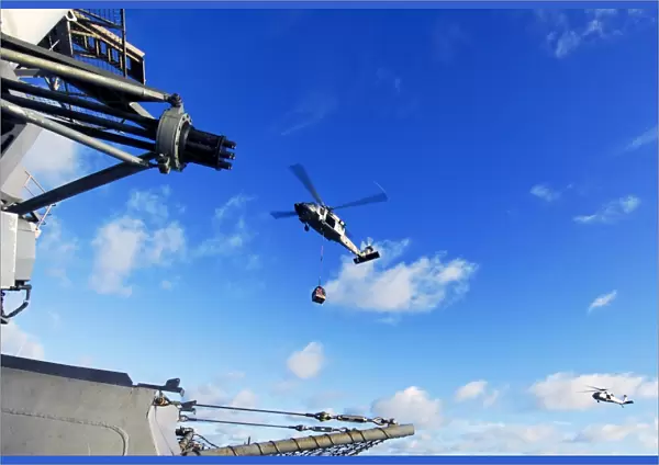 An MH-60S Sea Hawk helicopter transports cargo at sea