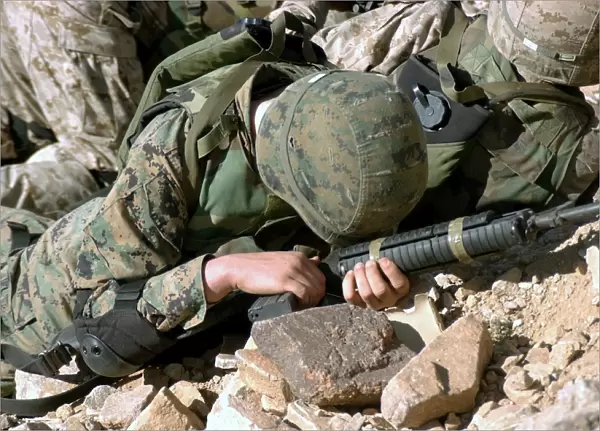 U. S. Marine Corps Private takes cover, protecting his 5. 56 mm M16A2 rifle