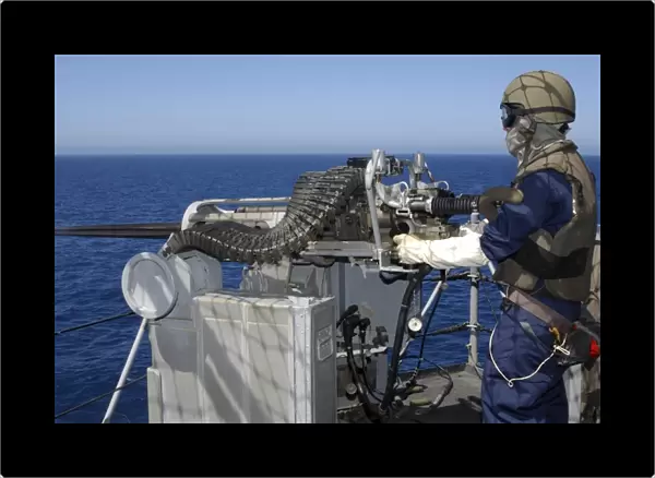 A U. S. Navy Gunners Mate firing a. 50-caliber machine gun during weapons training