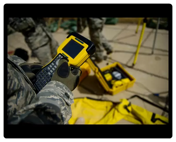U. S. Air Force Airman uses a satellite base station to collect data on terrain features