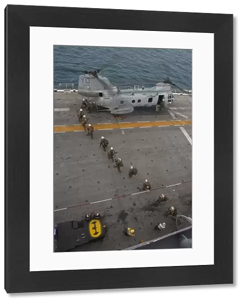 Marines embark a CH-46E Sea Stallion helicopter aboard USS Makin Island