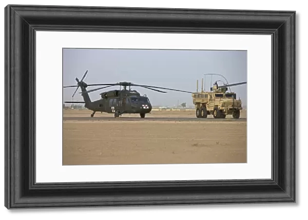 A UH-60 Black Hawk medevac helicopter and a RG-33 MRAP