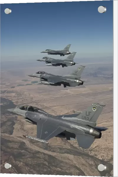 Four F-16s maneuver on a training mission over the Arizona desert