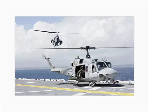 A UH-1N Huey and an AH-1W Super Cobra land on flight deck of USS Essex