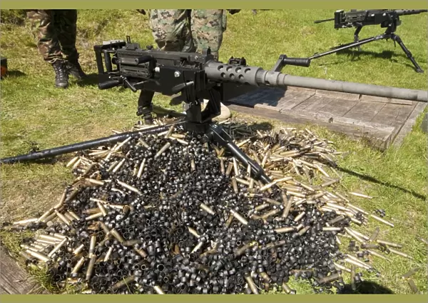 A. 50 Caliber Browning Machine Gun with a pile of spent cases and links