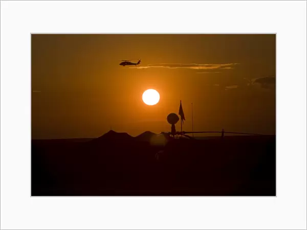 UH-60 Blackhawk flies over Camp Speicher airfield at sunset