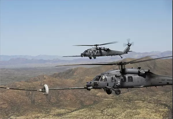 Two HH-60 Pave Hawks refuel over the desert surrounding Davis-Monthan Air Force Base