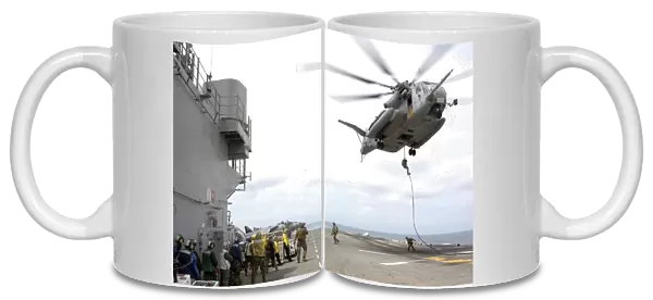 Marines and sailors fast-rope from a CH-53E Super Stallion