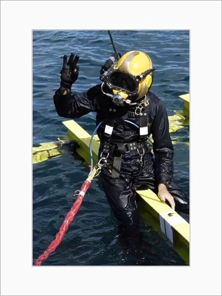 U. S. Navy Diver signals an OK sign to the dive supervisor