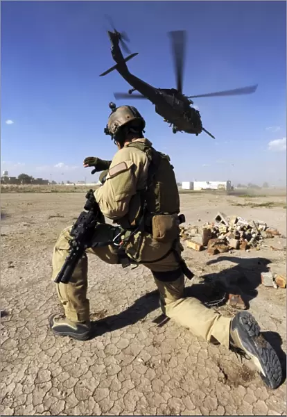 A soldier conducts security for an HH-60 Pavehawk helicopter