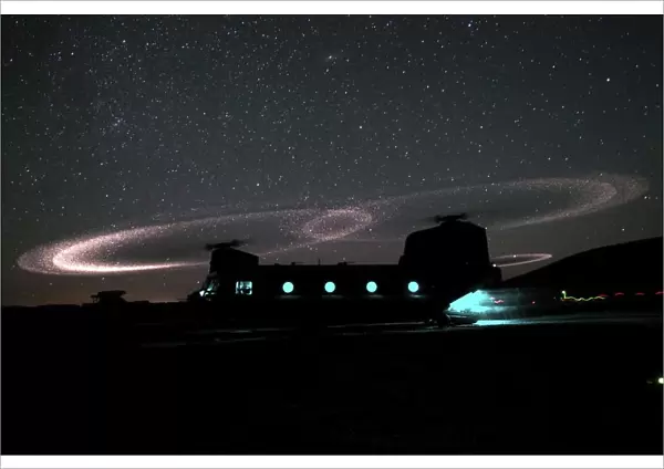 Dust lights up the rotors of a CH-47 Chinook helicopter