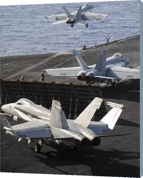 F  /  A-18 Hornets prepare to launch from the flight deck of USS Nimitz