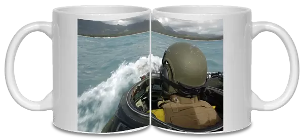 U. S. Marine driving an amphibious assault vehicle through the Pacific Ocean on coast