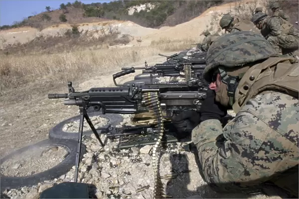 A corpsman fires an M249 Squad Automatic Weapon