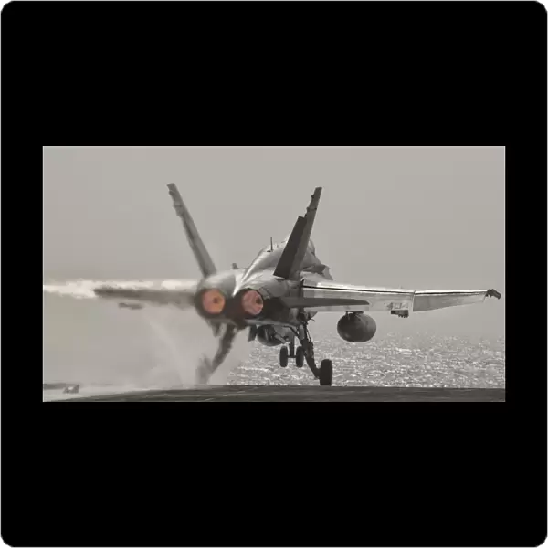 An F  /  A-18C Hornet takes off from USS George H. W. Bush