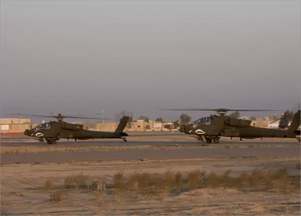 A pair AH-64D Apache Longbow Block III attack helicopters prepare for takeoff