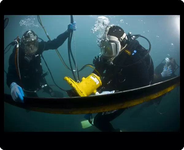 U. S. Navy Diver instructs a Barbados coast guard diver on using a hydraulic grinder