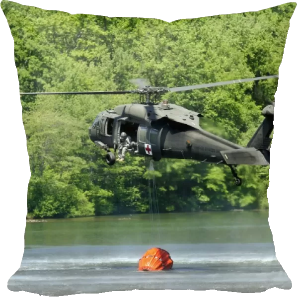 A UH-60 Blackhawk helicopter fills a suspended water bucket in Marquette Lake, Pennsylvania