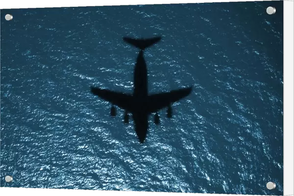 Silhouette of a military aircraft in flight over the Atlantic Ocean