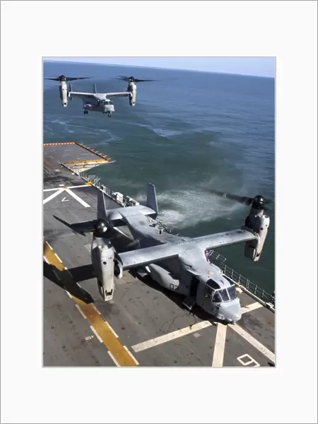 Two MV-22 Ospreys land on the flight deck of USS Nassau