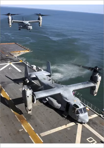 Two MV-22 Ospreys land on the flight deck of USS Nassau