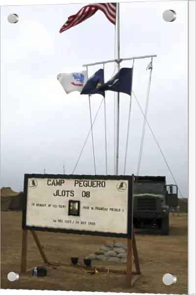 Camp Peguero sign and central flag pole for the Navy, Army and Marine forces camp site