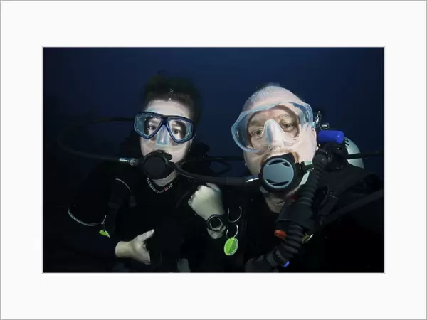 Scuba divers pose for the camera underwater