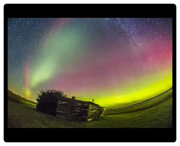 Fish-eye lens view of the northern lights above an old ranch in Canada