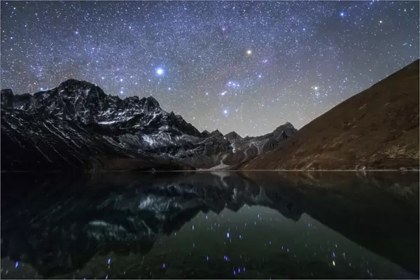 Celestial sky with Sirius, Orion and Aldebaran shining bove Pharilapche Peak in Nepal
