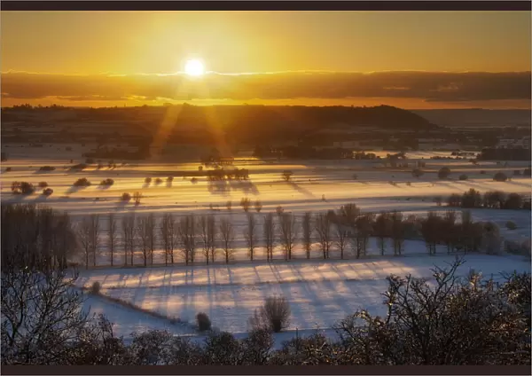 Winter sunset over the Somerset Levels from Walton Hill on a misty evening with snow on the ground