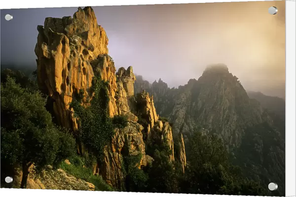Rock formations in the fog at sunset, in the Calanche of Piana, Gulf of Porto UNESCO