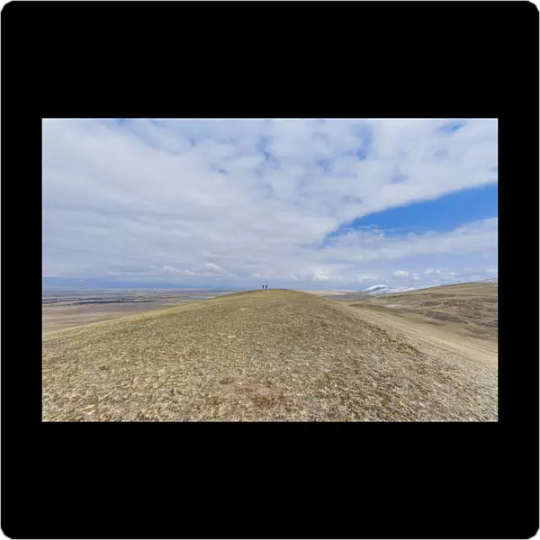 Two people walking in vast landscape with dry grass Barguzin Valley, Buryatial, Siberia