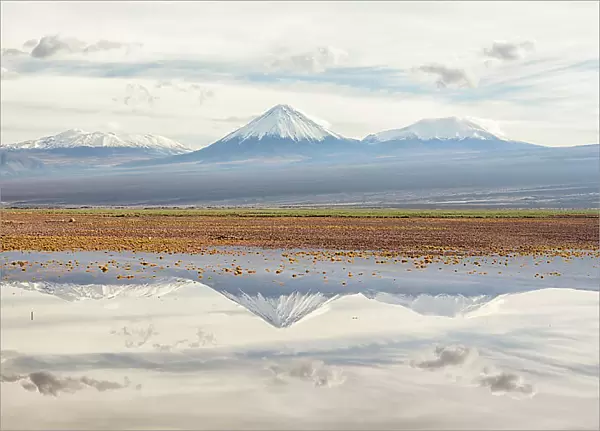Licancabur volcano and surrounding mountains reflected in waters of a severe flood caused by climate change. Los Flamencos National Reserve, Antofagasta, Chile. February 2019