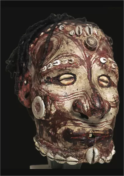 Human skull with features modelled in clay and painted, from New Guinea