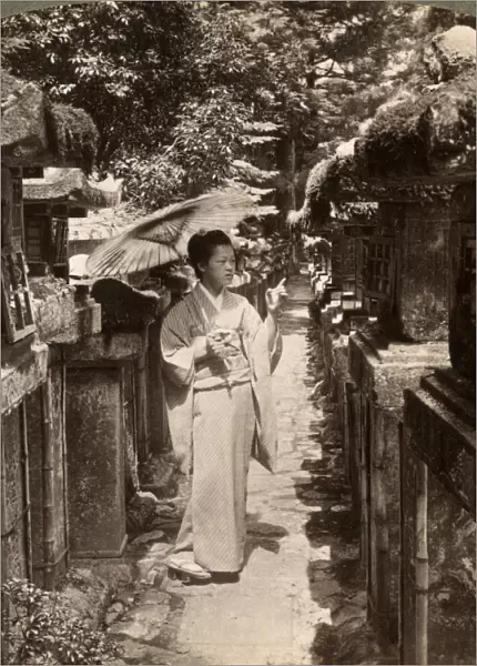 A woman Shinto devotee counting the stone lanterns, Kasuga Shrine, Nara, Japan, 1904. Artist: Underwood & Underwood