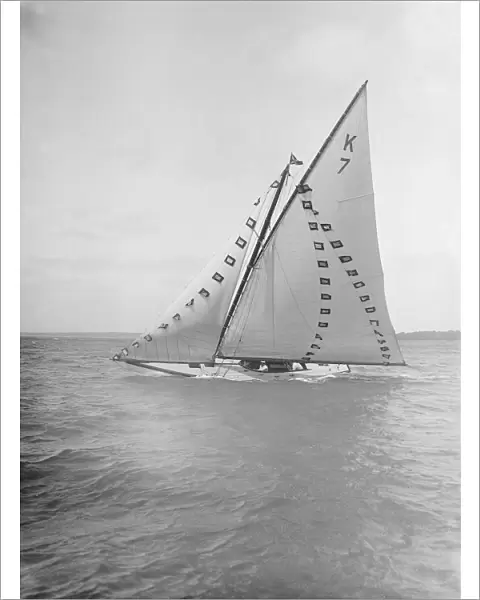 The 7 Metre Ginerva (K7) under sail with prize flags, 1912. Creator: Kirk & Sons of Cowes