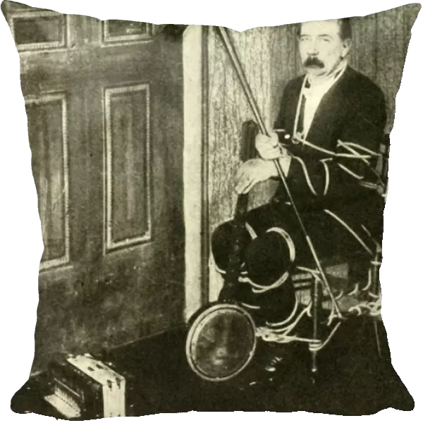 John Nevil Maskelyne performs a spirit cabinet illusion, c1910. Creator: Unknown