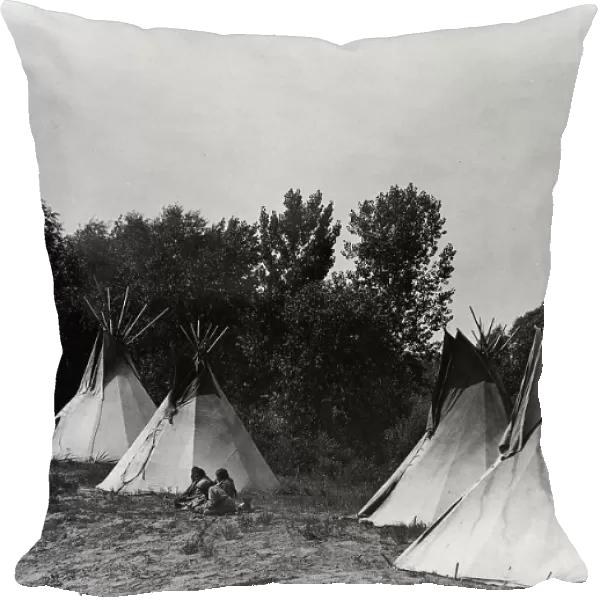 An Assiniboin camp containing four tepees with Indians seated on ground, c1908. Creator: Edward Sheriff Curtis